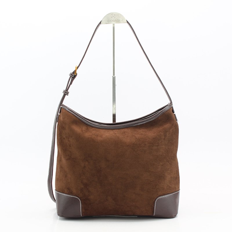 A brown suede shoulder bag featuring a sleek metal handle.